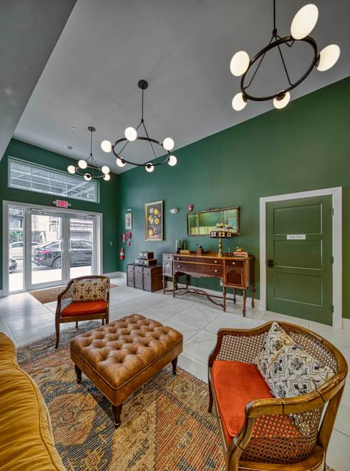A room with a green wall and a wooden chair.