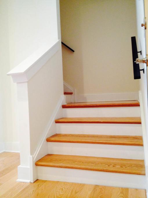 A staircase with wooden steps and white railings.