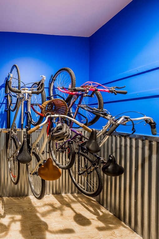 A bunch of bicycles hanging on a wall.