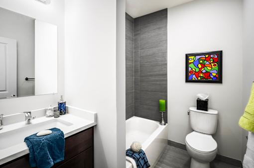A bathroom with a white toilet, a white sink, a white bathtub, and a white towel.