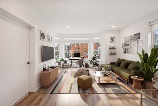 A living room with a green couch and a wooden floor.
