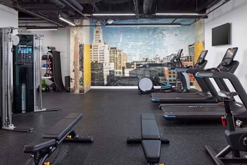 A gym with treadmills, weights, and a city view mural on the wall.at 1600 Callowhill, Philadelphia, PA
