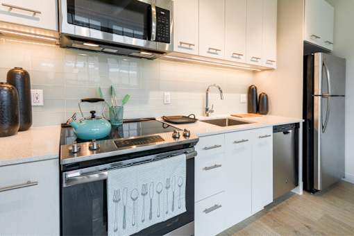 A modern kitchen with white cabinets and a black stove top.at 1600 Callowhill, Philadelphia, PA