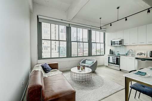 A modern living room with a brown leather couch and a large window.at 1600 Callowhill, Philadelphia, 19130