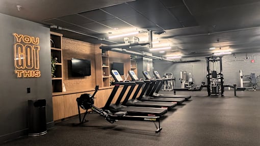 A gym with a row of rowing machines and a sign that says "You Got This".