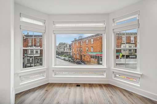 A room with three windows showing different views of a street.