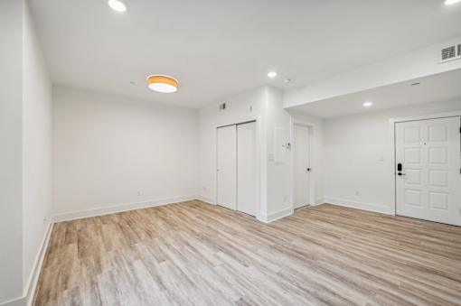 A room with wooden flooring and white walls.