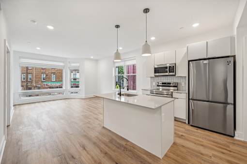 A modern kitchen with a white island and stainless steel appliances.