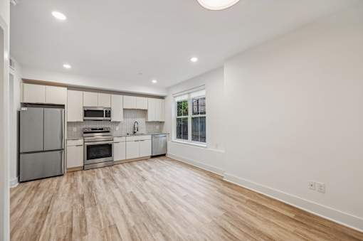 A kitchen with wooden floors and white walls.