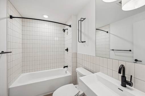 A white bathroom with a white tub and sink.