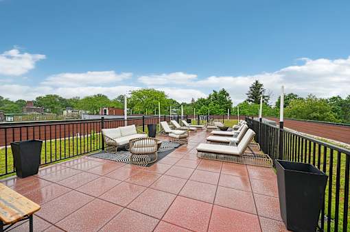 A patio with a table and chairs overlooking a green area.