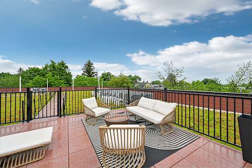 A patio with a black railing and furniture.