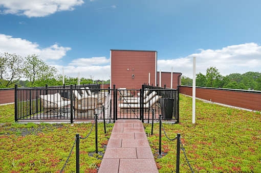 A red building with a black fence and a walkway leading to it.