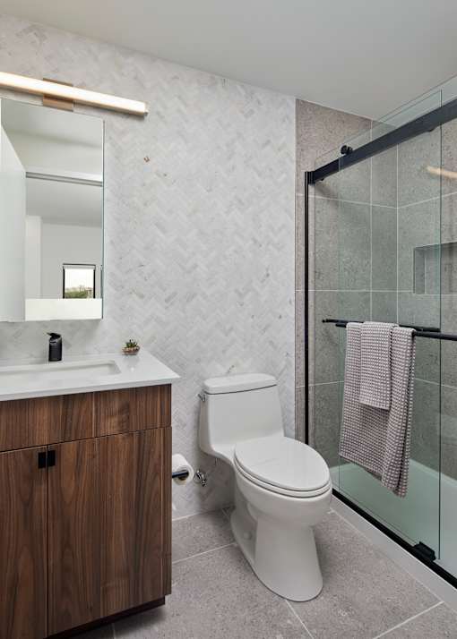 A white toilet sits next to a sink in a bathroom. at 23 West Apartments, Philadelphia, PA