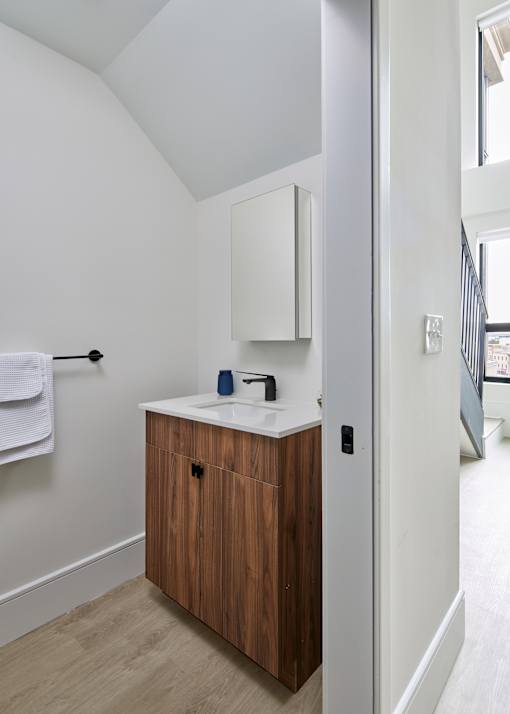 A bathroom with a white sink and a wooden cabinet. at 23 West Apartments, Philadelphia, PA