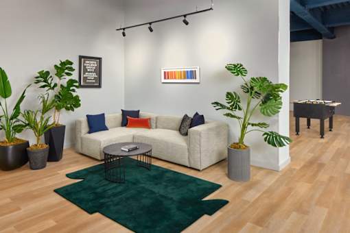 A living room with a white couch, a green rug, and a coffee table.