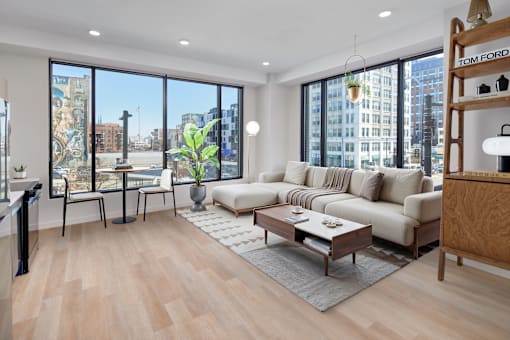 A living room with a large window overlooking a city street.