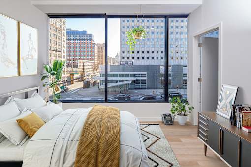 A bedroom with a large bed and a view of the city.