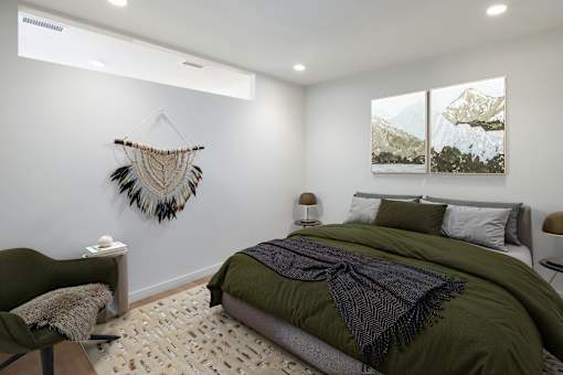 A bedroom with a green bed and a wall hanging.
