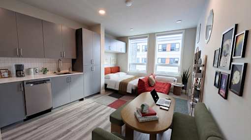 A modern kitchen with a green couch and a table with a book on it.