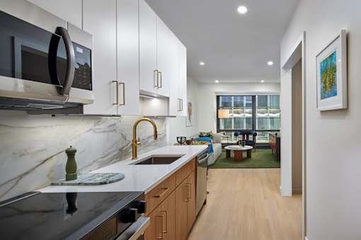 A modern kitchen with a marble countertop and stainless steel appliances.