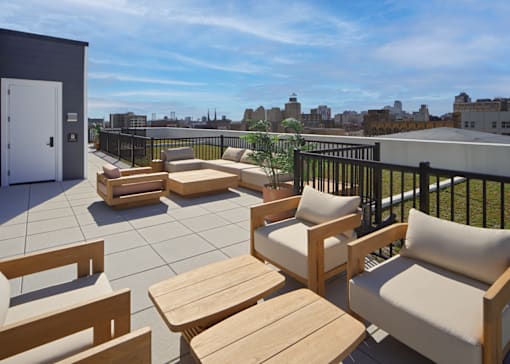 A patio with wooden furniture and a view of the city.