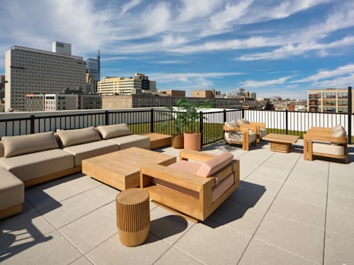 A wooden table and chairs are set up on a rooftop patio.