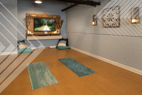 A room with a wooden floor and a television mounted on the wall.