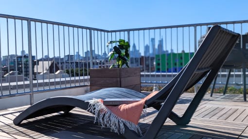 a lounge chair on a balcony with a view of the city