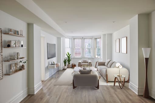 A well-lit, spacious living room with a grey sofa and a wooden floor.
