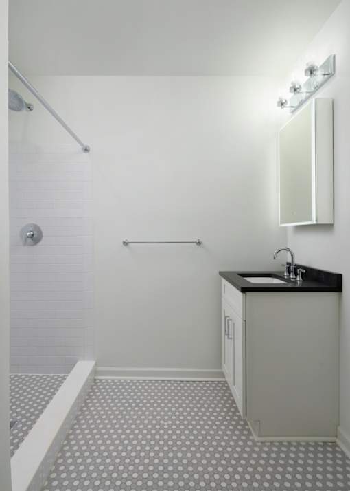 A bathroom with a sink and a shower.