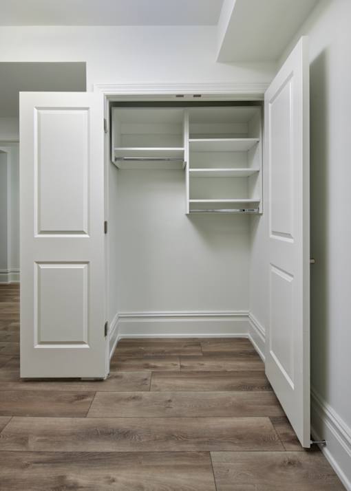 A white closet with shelves and a white door.