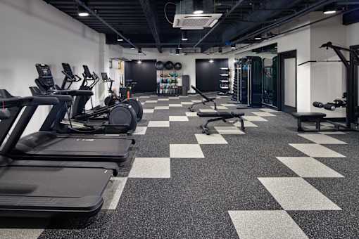 A gym with treadmills, weights, and a checkerboard floor. at The Weaver, Philadelphia, PA, 19125