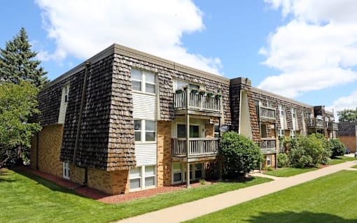 A large apartment building with cars parked in front.