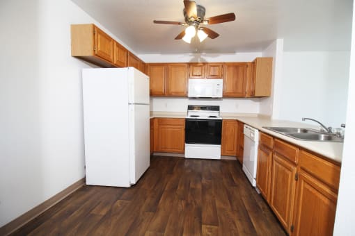 a kitchen with a white refrigerator freezer next to a stove top oven