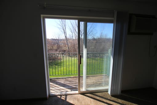 a bedroom with a sliding glass door leading to a balcony