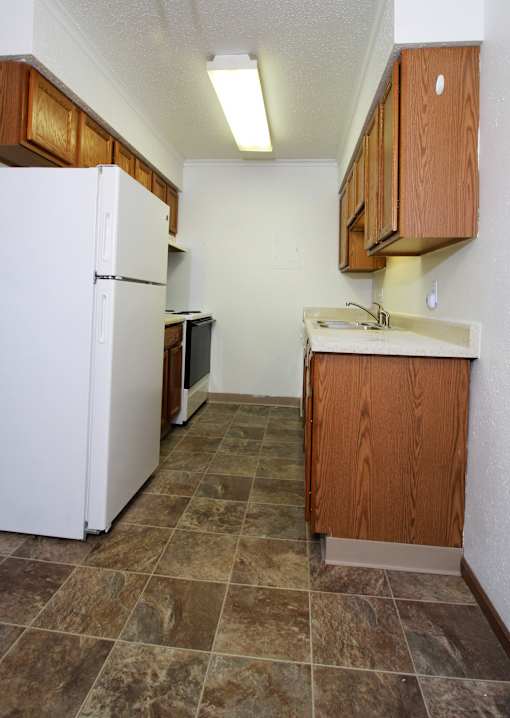 a kitchen with white appliances and wooden cabinets