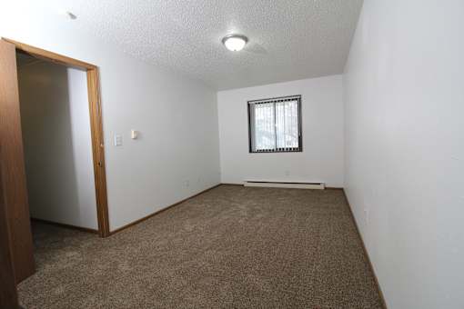 a small empty room with a window and a door