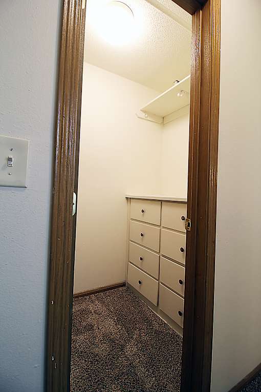 A white door with a light switch on the wall.