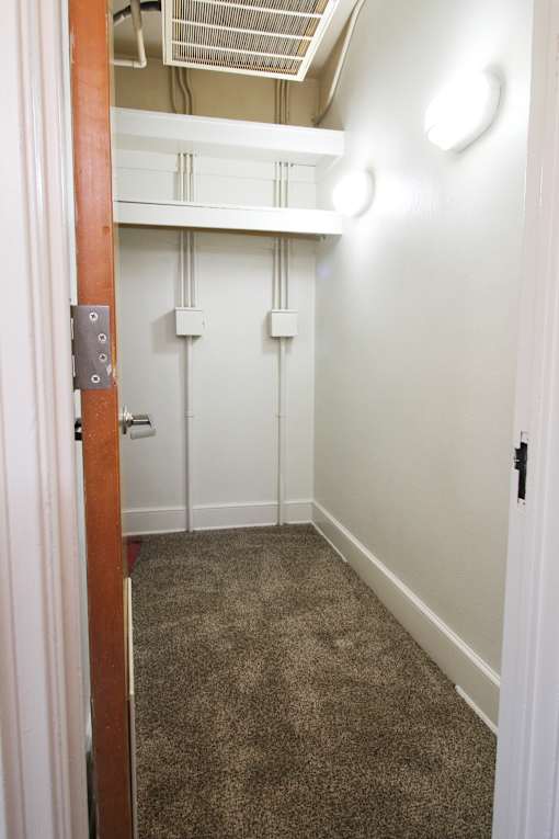 a nice size closet with a carpeted floor and white walls
