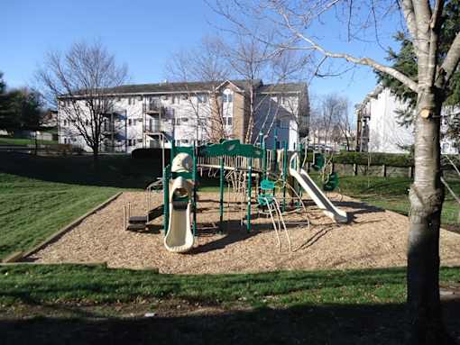 a playground in a park with a building in the background