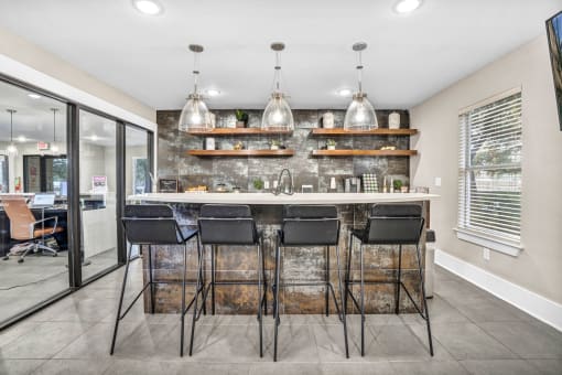 a kitchen with a bar and chairs in front of a window at Sunset Ridge, San Antonio, Texas