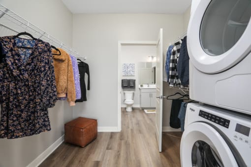 a laundry room with a washer and dryer and a door to a bathroom at Beekman on Broadway, Ann Arbor, MI, 48105