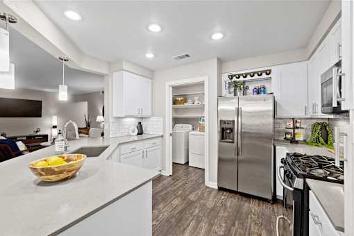 a kitchen with white cabinets and stainless steel appliances