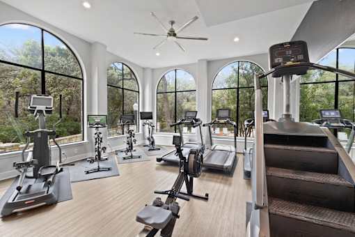 a gym with a row of windows and various exercise equipment