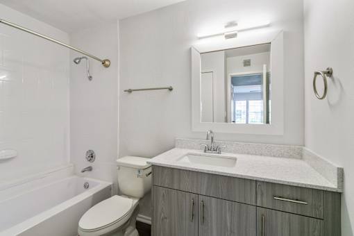 A bathroom with a toilet, sink, and tub.