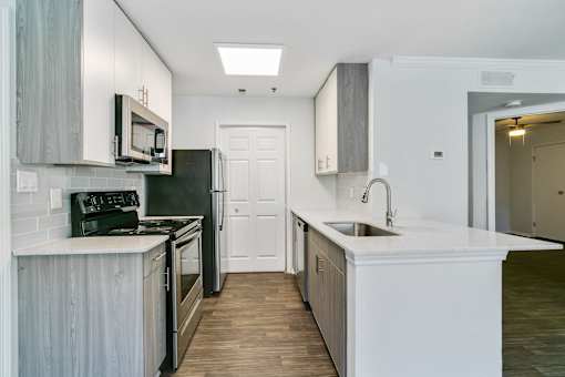 A kitchen with a black refrigerator and stove.