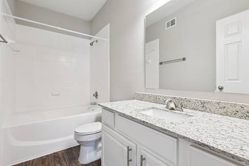 A white bathroom with a tub, toilet and sink.