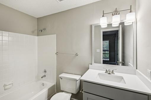 A white bathroom with a toilet, sink, and bathtub.
