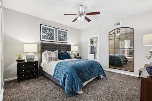 A bedroom with a bed, dresser, and mirror.